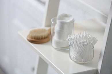 Photo of Cotton buds on white rack in bathroom