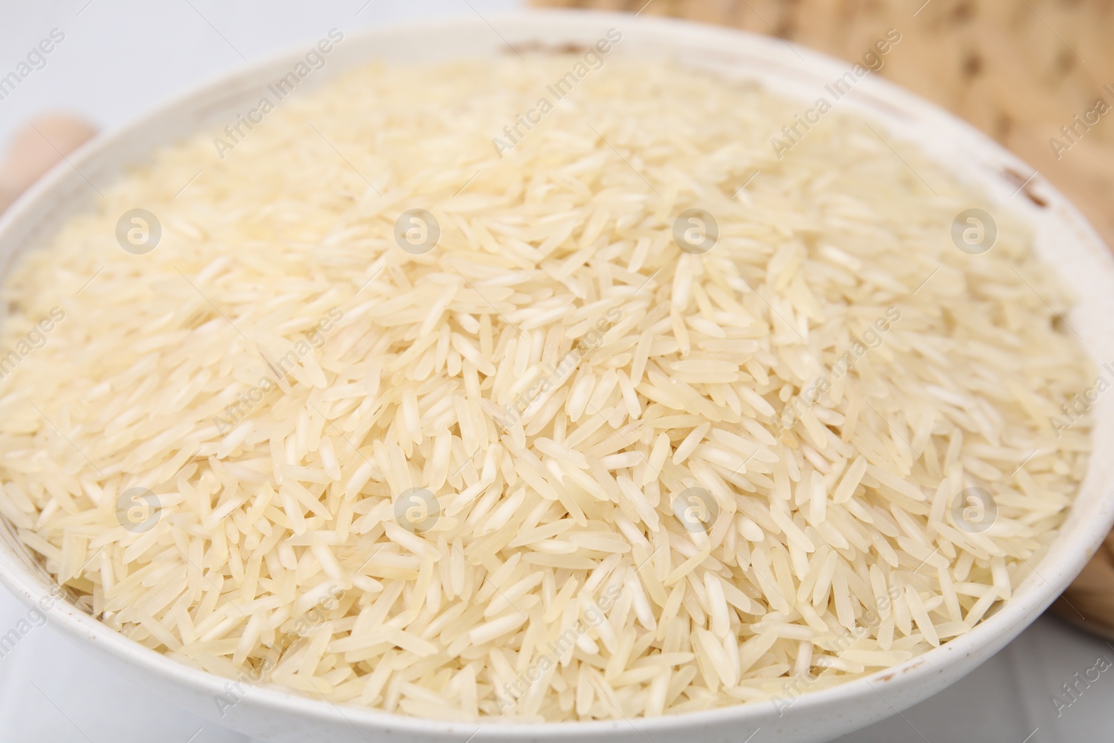 Photo of Raw rice in bowl on table, closeup