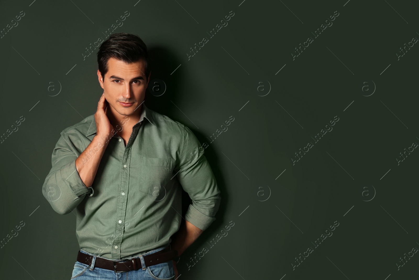 Photo of Handsome young man in stylish clothes on dark background. Space for text