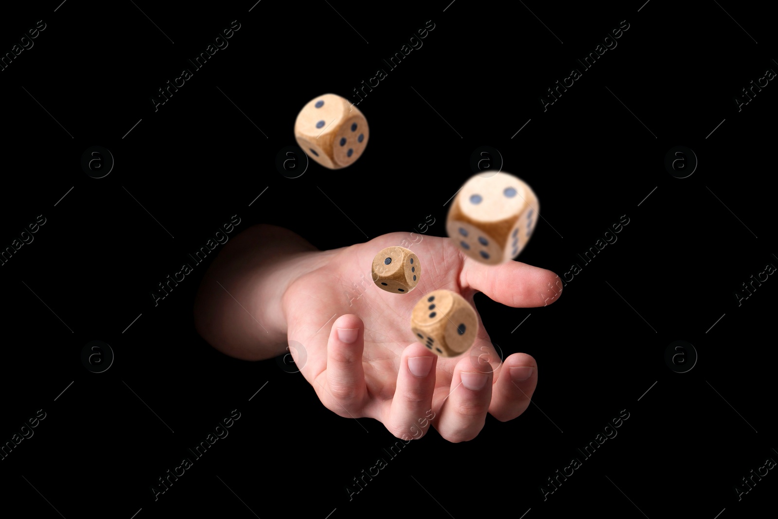 Image of Man throwing wooden dice on black background, closeup