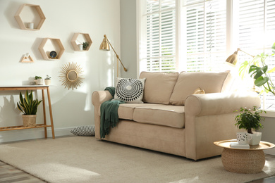 Photo of Stylish beige sofa in modern living room interior