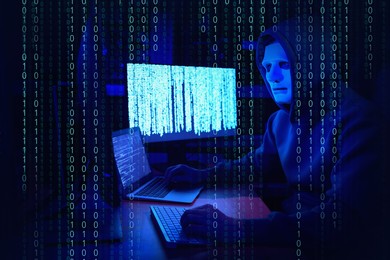 Image of Anonymous man in mask with computers and binary code in darkness