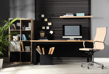 Photo of Comfortable workplace with computer and office chair. Stylish room interior