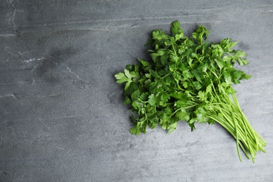 Photo of Bunch of fresh green parsley on grey background, view from above. Space for text