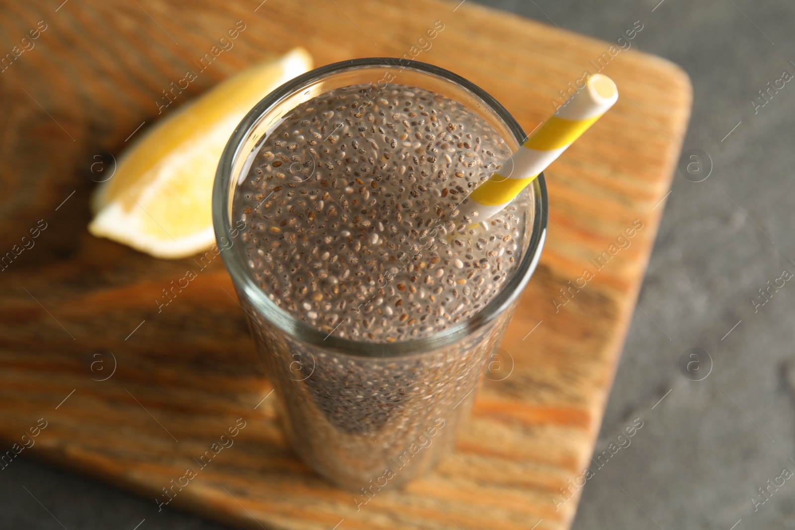 Photo of Glass of water with chia seeds on board, closeup