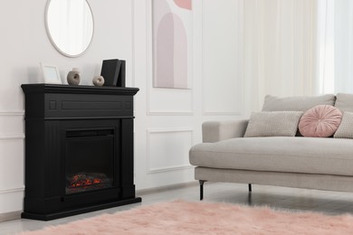 Photo of Black stylish fireplace near comfortable sofa in cosy living room