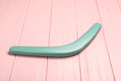 Photo of Boomerang on pink wooden background. Outdoors activity