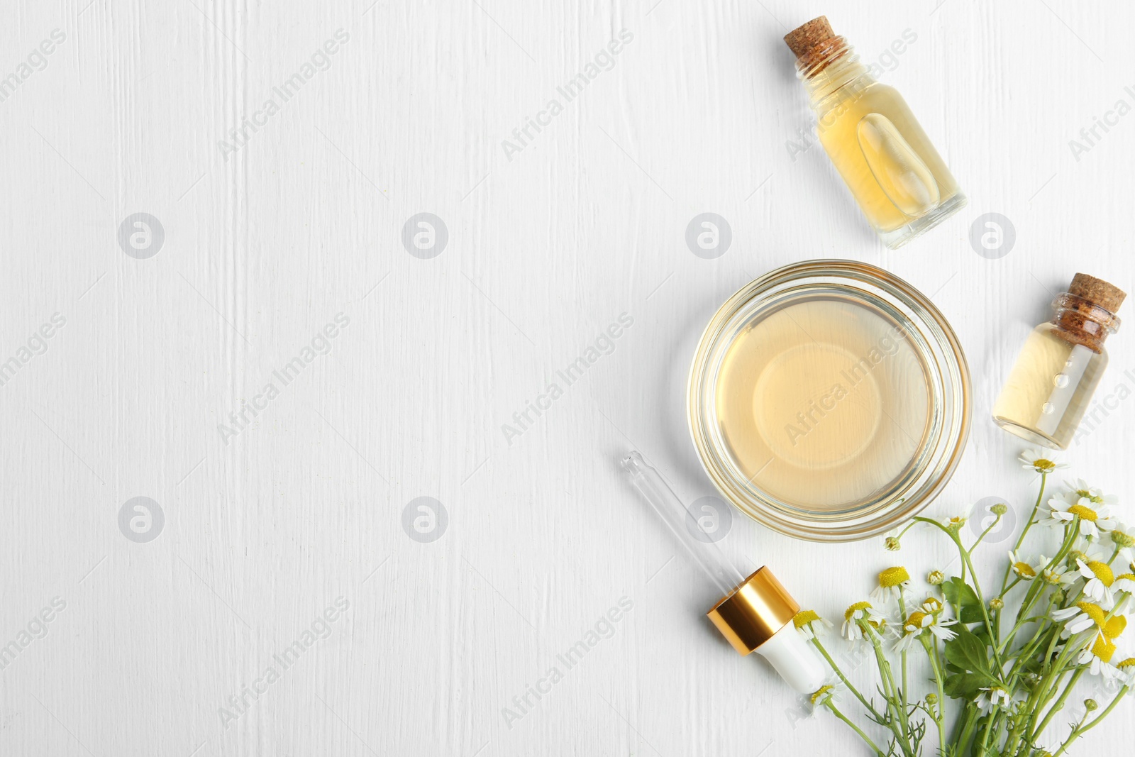 Photo of Flat lay composition with chamomile essential oil on white wooden background. Space for text