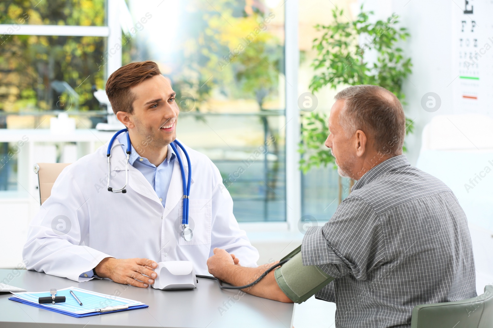 Photo of Doctor measuring blood pressure of mature patient in hospital