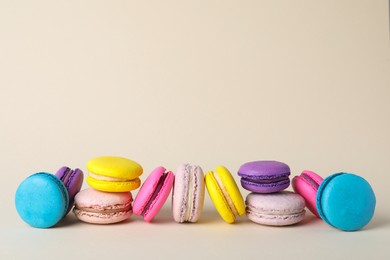 Delicious colorful macarons on beige background. Space for text