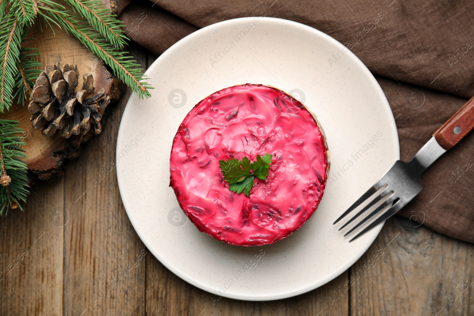 Photo of Herring under fur coat served on wooden table, flat lay. Traditional russian salad