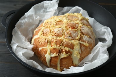Freshly baked bread with tofu cheese and lemon zest on black wooden table, closeup