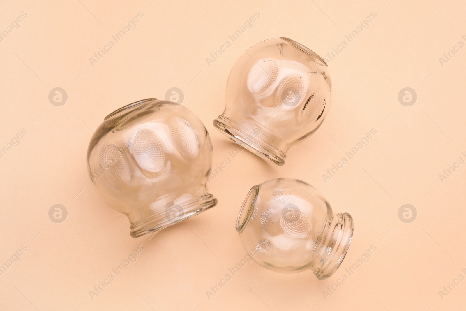 Photo of Glass cups on light coral background, flat lay. Cupping therapy