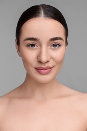 Portrait of beautiful young woman on grey background