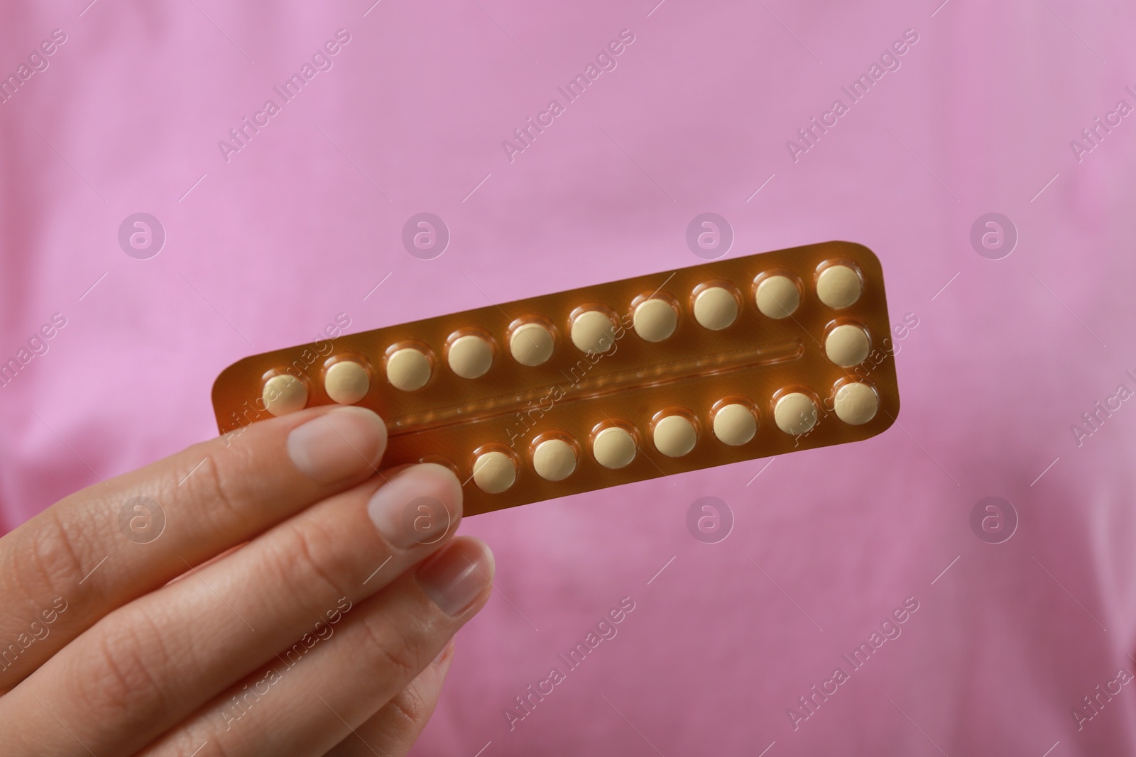 Photo of Woman holding blister with birth control pills, closeup