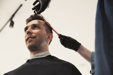 Professional barber working with client in hairdressing salon. Hipster fashion