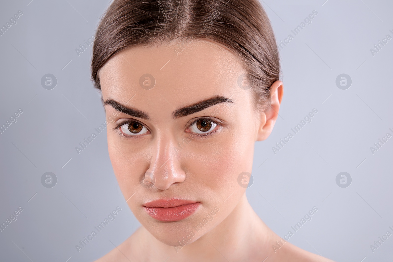 Photo of Beautiful woman with perfect eyebrows on light background