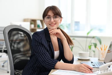 Photo of Portrait of smiling secretary at table in office