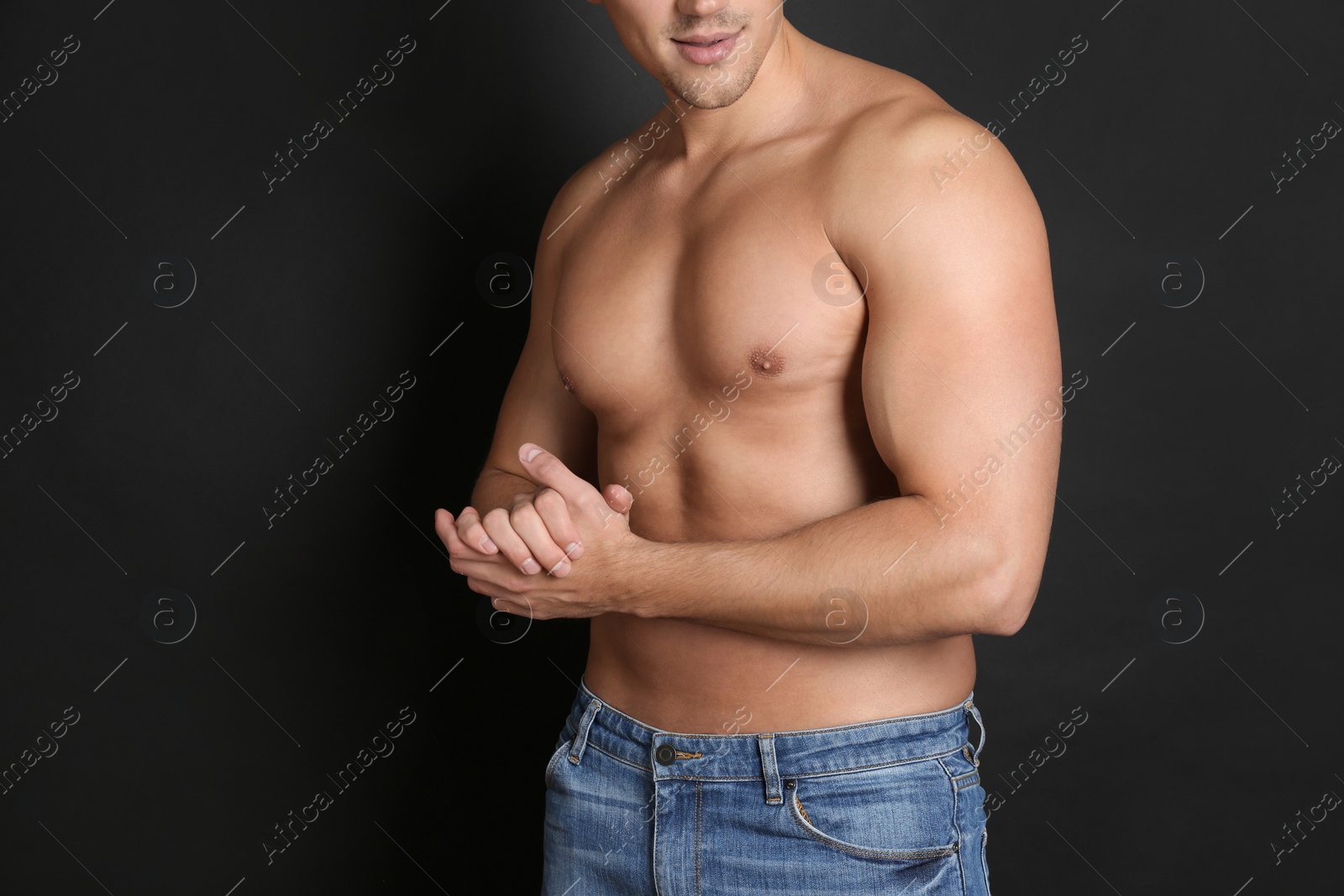 Photo of Man with sexy body on black background, closeup