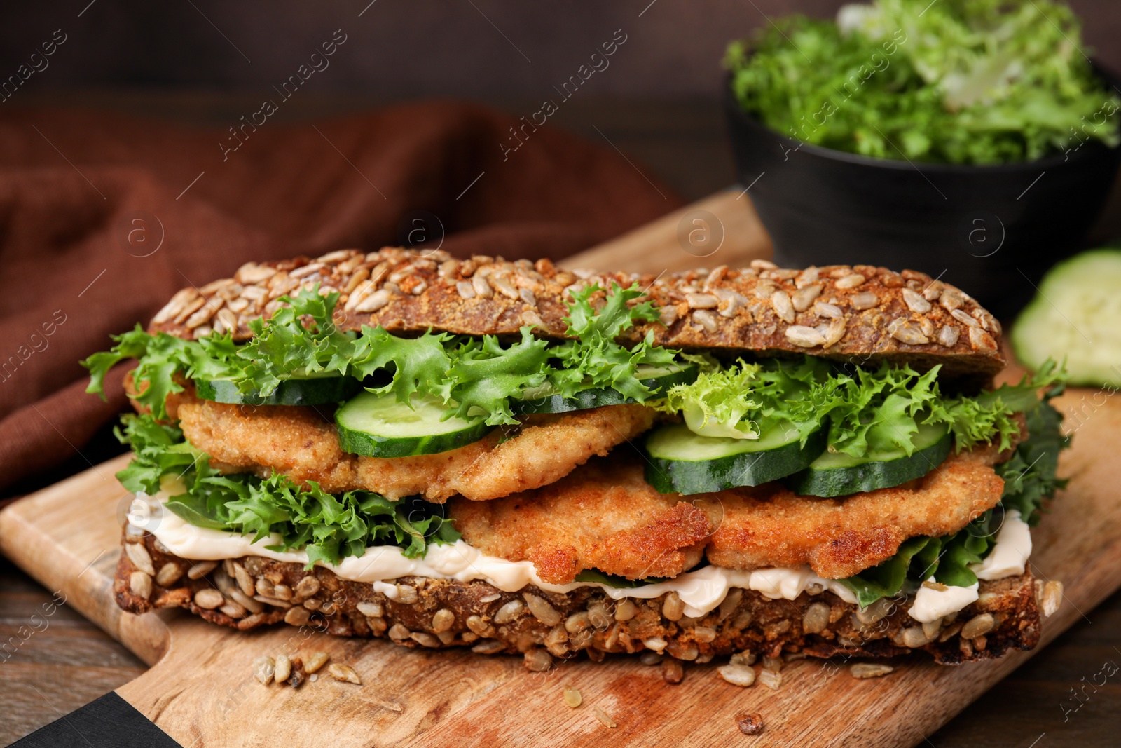 Photo of Delicious sandwich with schnitzel on wooden table, closeup