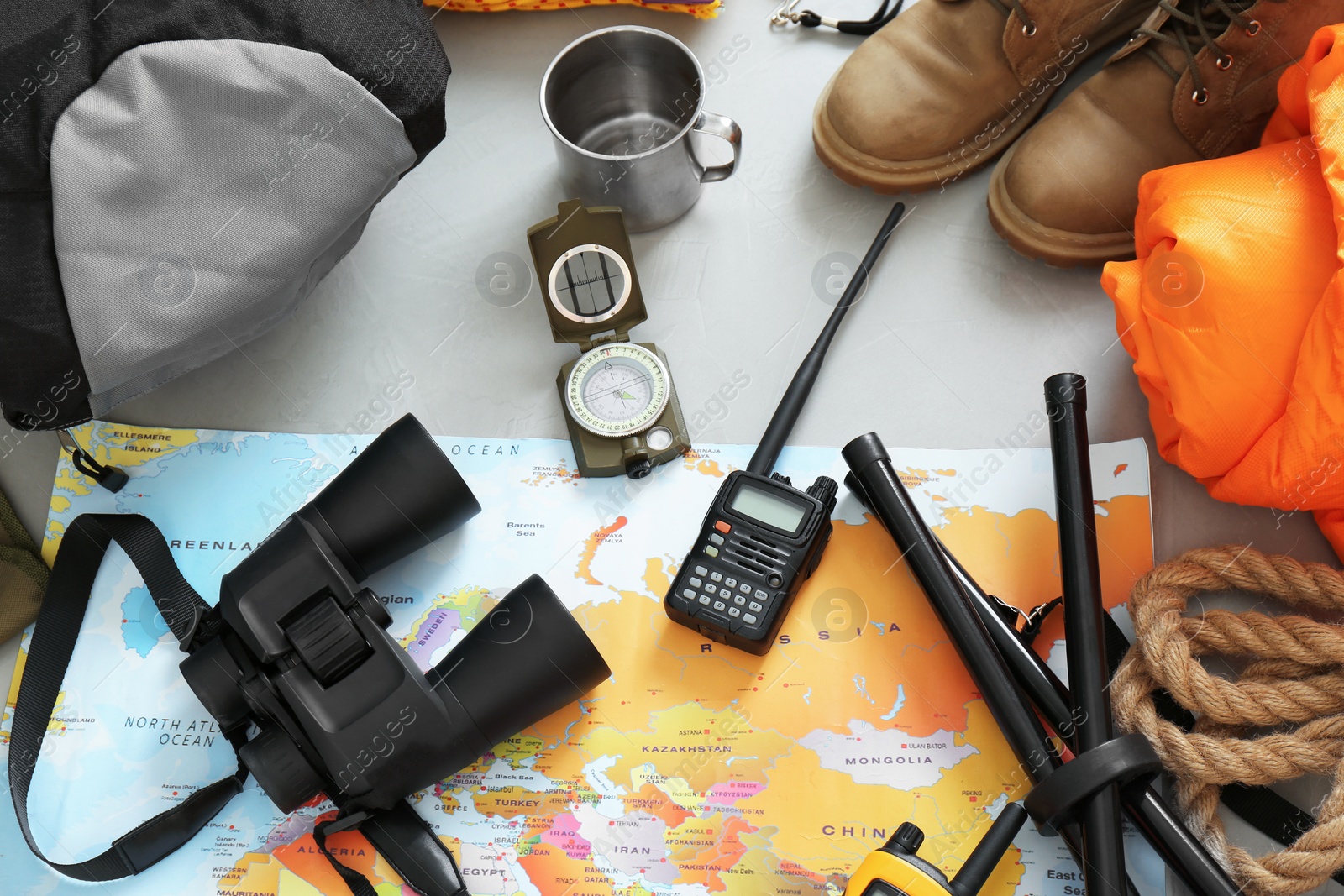 Photo of Flat lay composition with sleeping bag and camping equipment on grey background