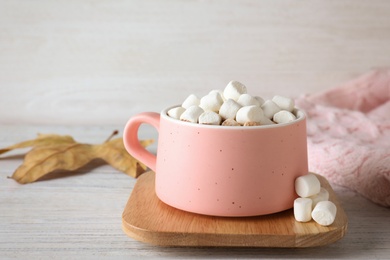 Photo of Cup of hot drink on white wooden table. Cozy autumn atmosphere