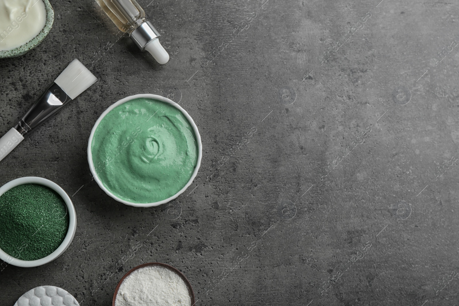 Photo of Flat lay composition with spirulina facial mask and ingredients on grey table. Space for text