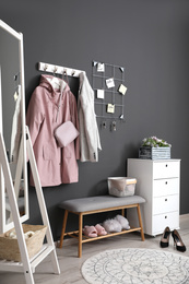 Photo of Hallway interior with stylish furniture, clothes and accessories
