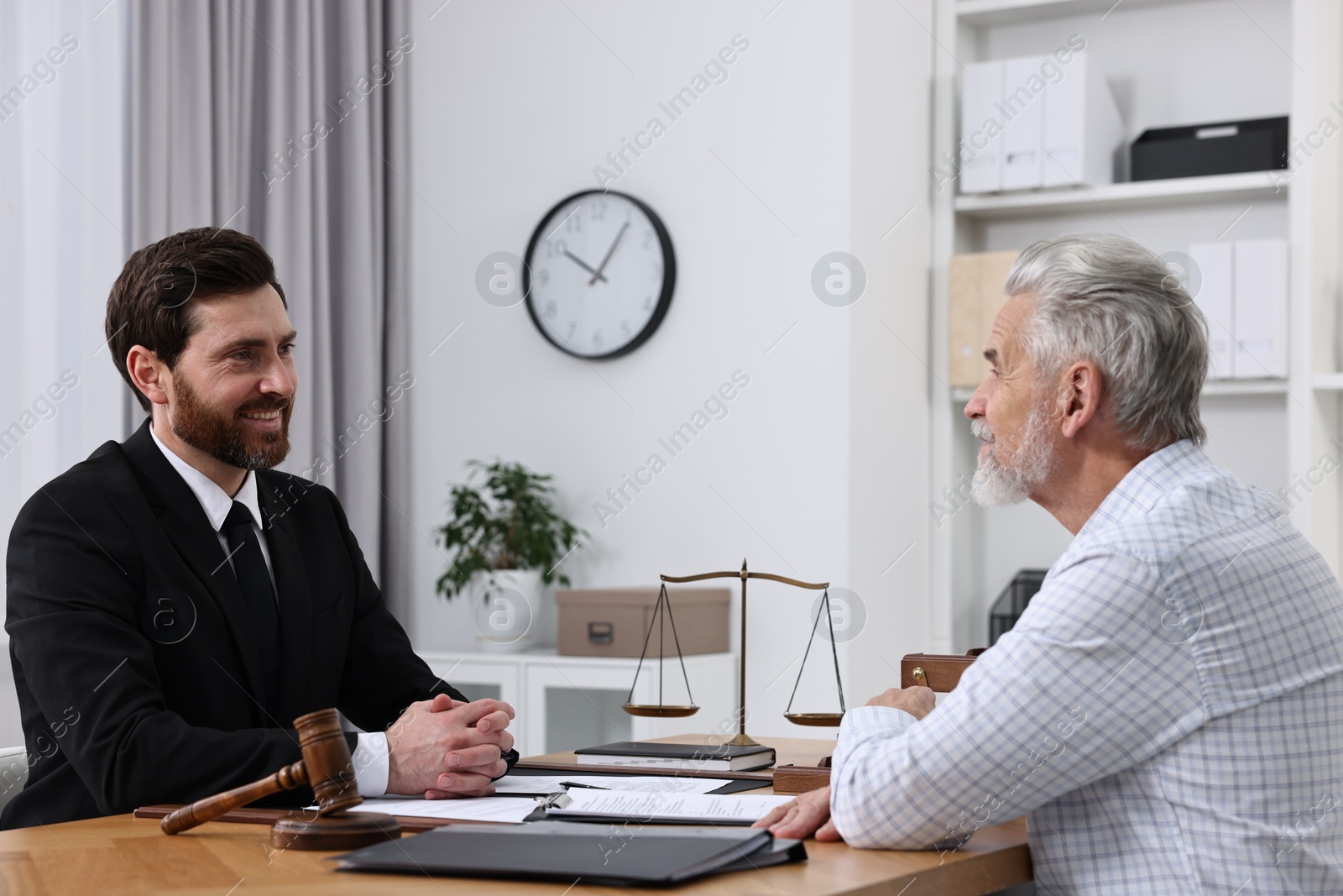 Photo of Senior man having meeting with lawyer in office