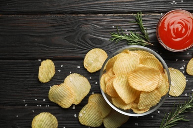 Flat lay composition with potato chips on wooden table. Space for text