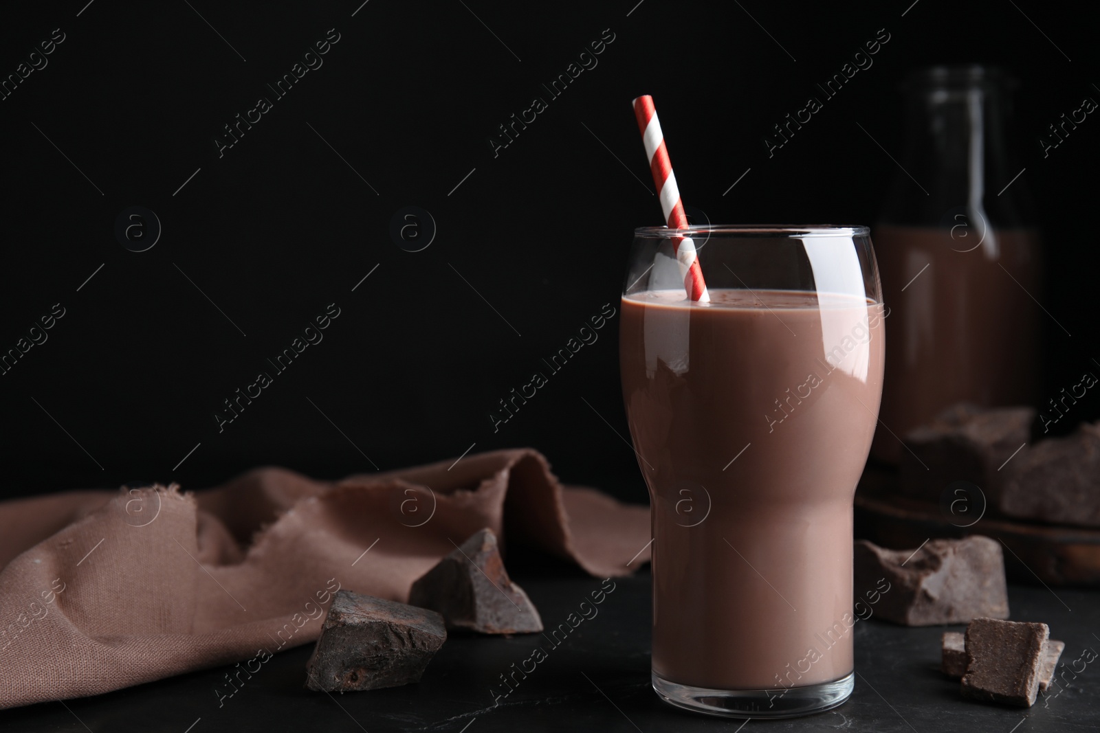 Photo of Delicious chocolate milk on black table. Space for text
