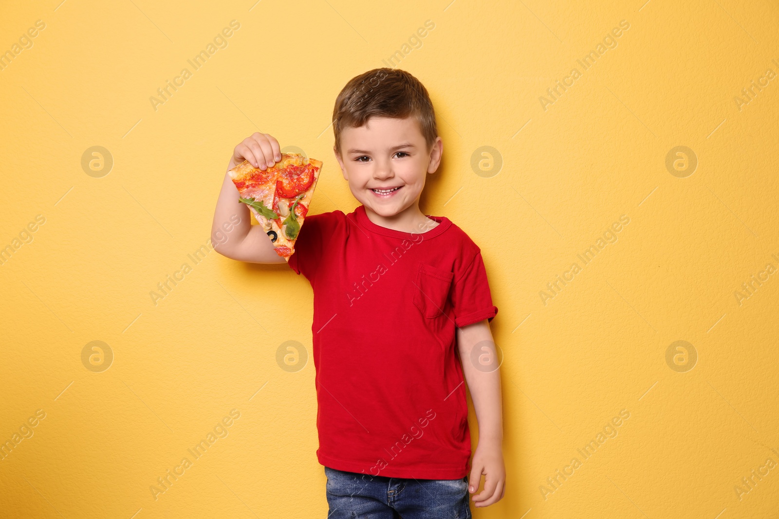 Photo of Cute little boy with slice of pizza on color background