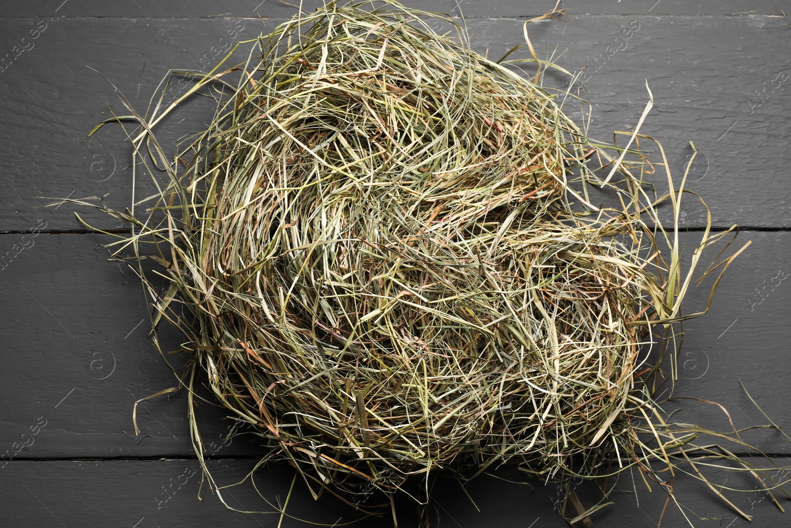 Photo of Dried hay on grey wooden table, top view