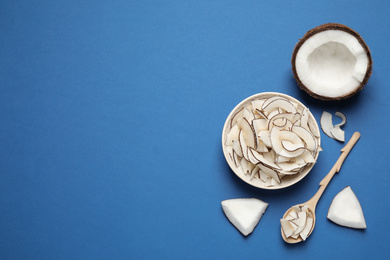 Photo of Flat lay composition with tasty coconut chips on blue background. Space for text