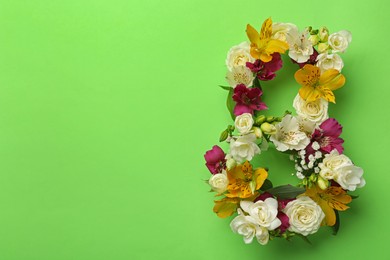 Number 8 made of beautiful flowers on green background, flat lay with space for text. International Women's day