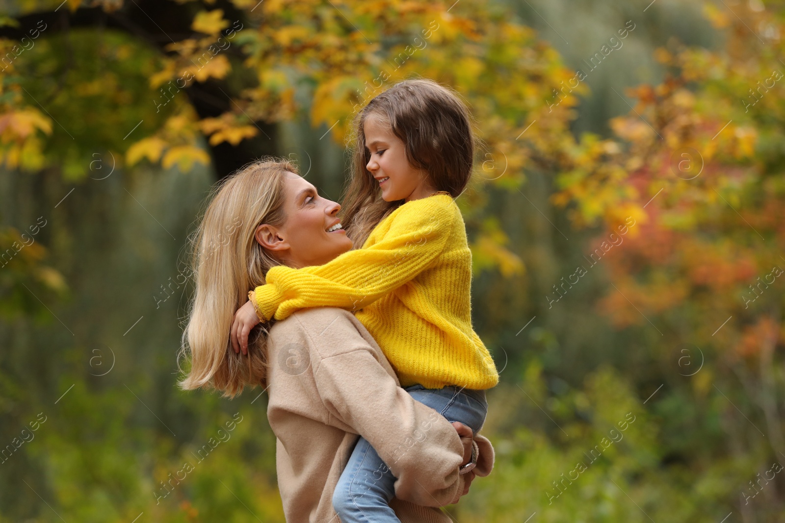 Photo of Happy mother with her daughter in autumn park