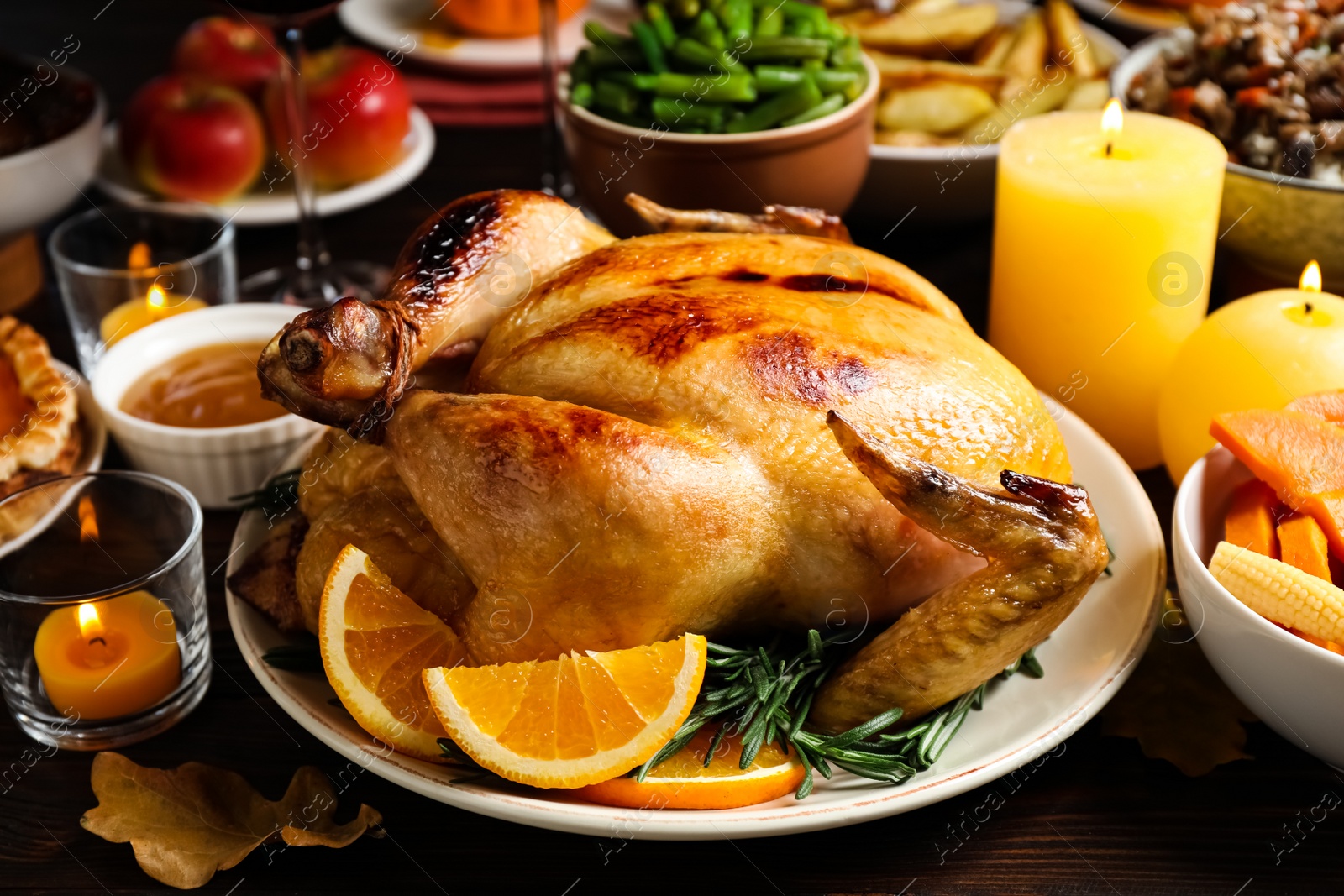 Photo of Traditional Thanksgiving day feast with delicious cooked turkey and other seasonal dishes served on wooden table, closeup