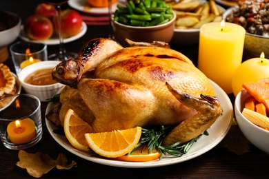 Traditional Thanksgiving day feast with delicious cooked turkey and other seasonal dishes served on wooden table, closeup