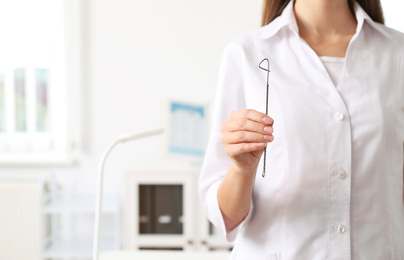 Photo of Speech therapist with logopedic probe in clinic, closeup. Space for text