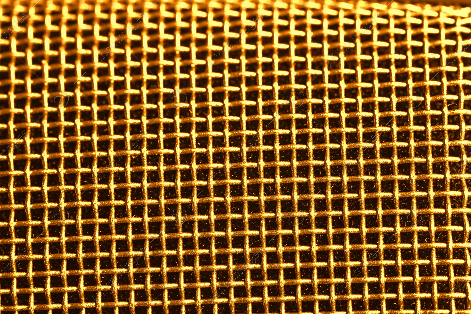 Image of Metal mesh of golden microphone as background, closeup