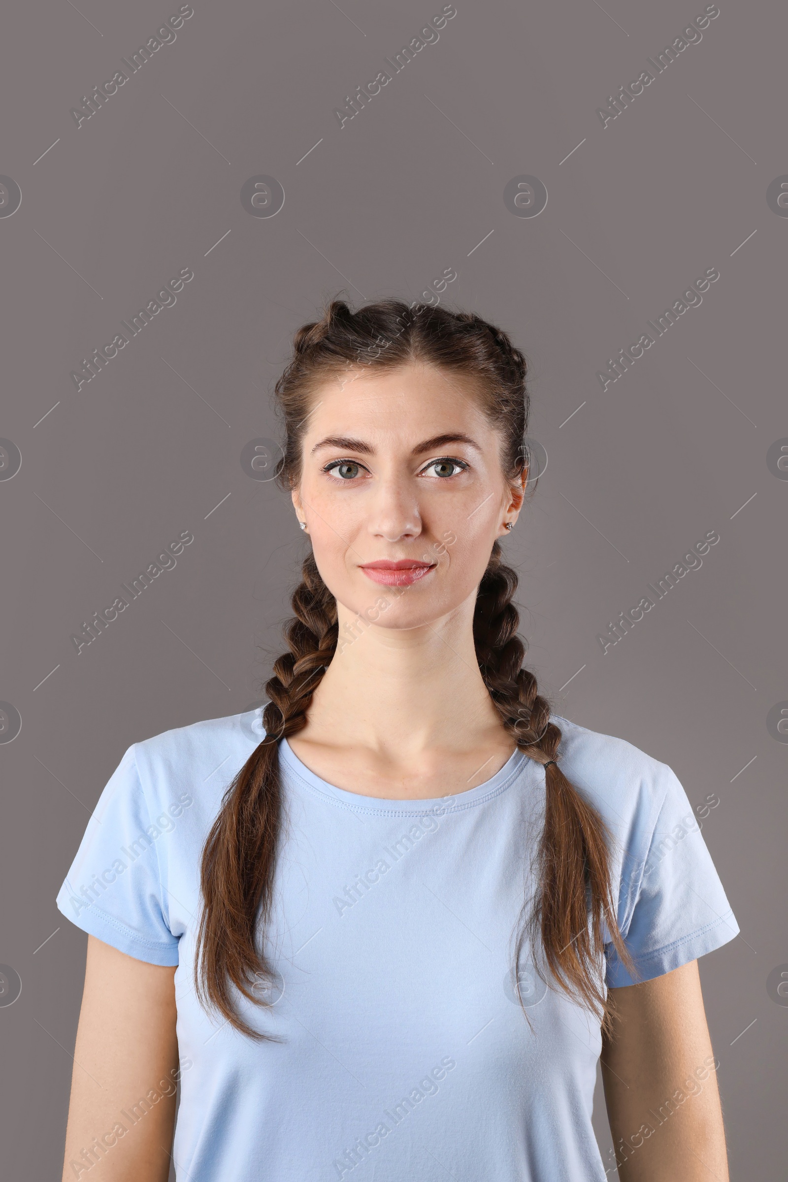 Photo of Woman with braided hair on grey background