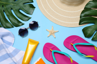 Photo of Flat lay composition with beach objects on light blue background