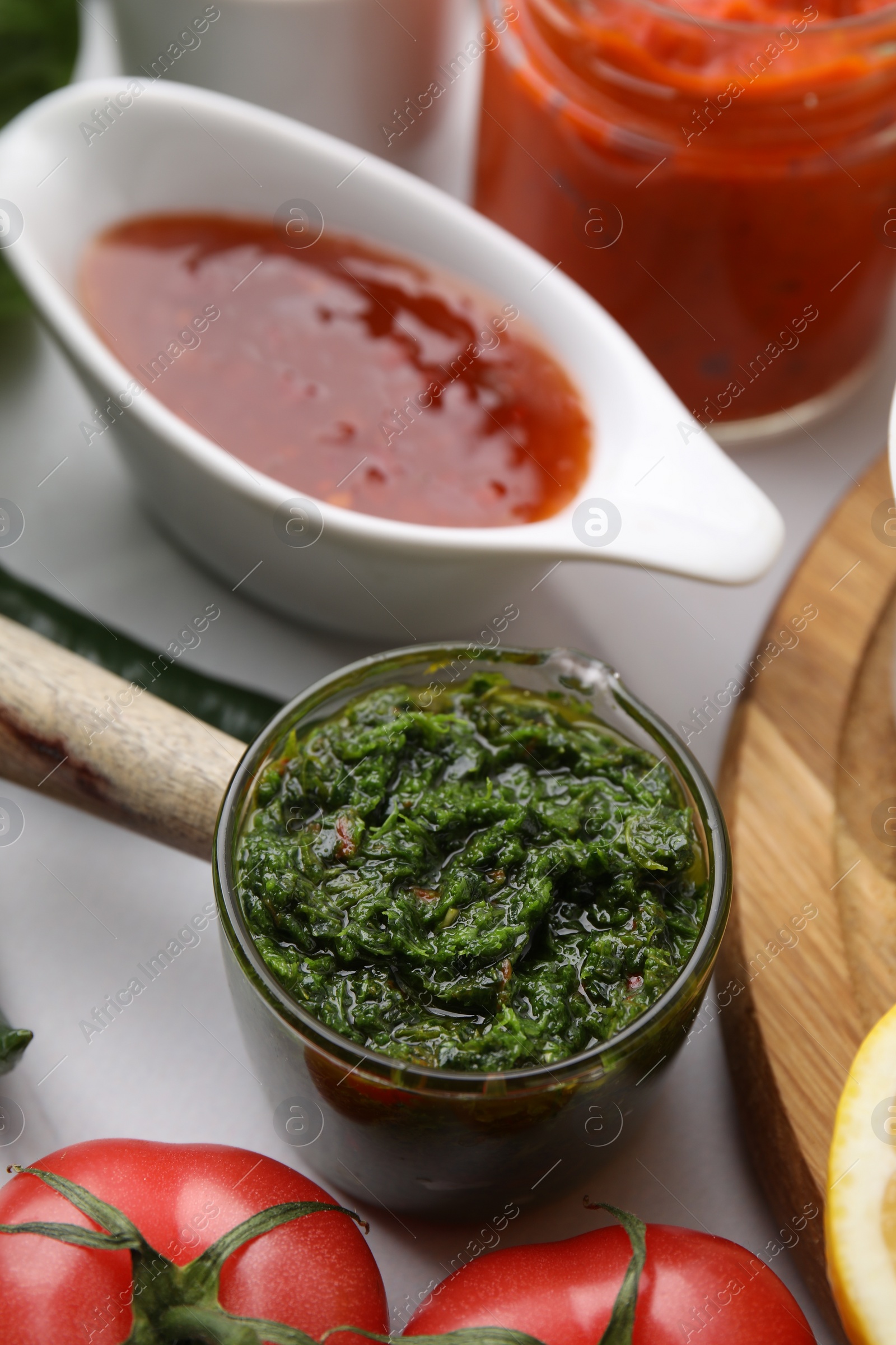 Photo of Different marinades in tableware on white table, closeup