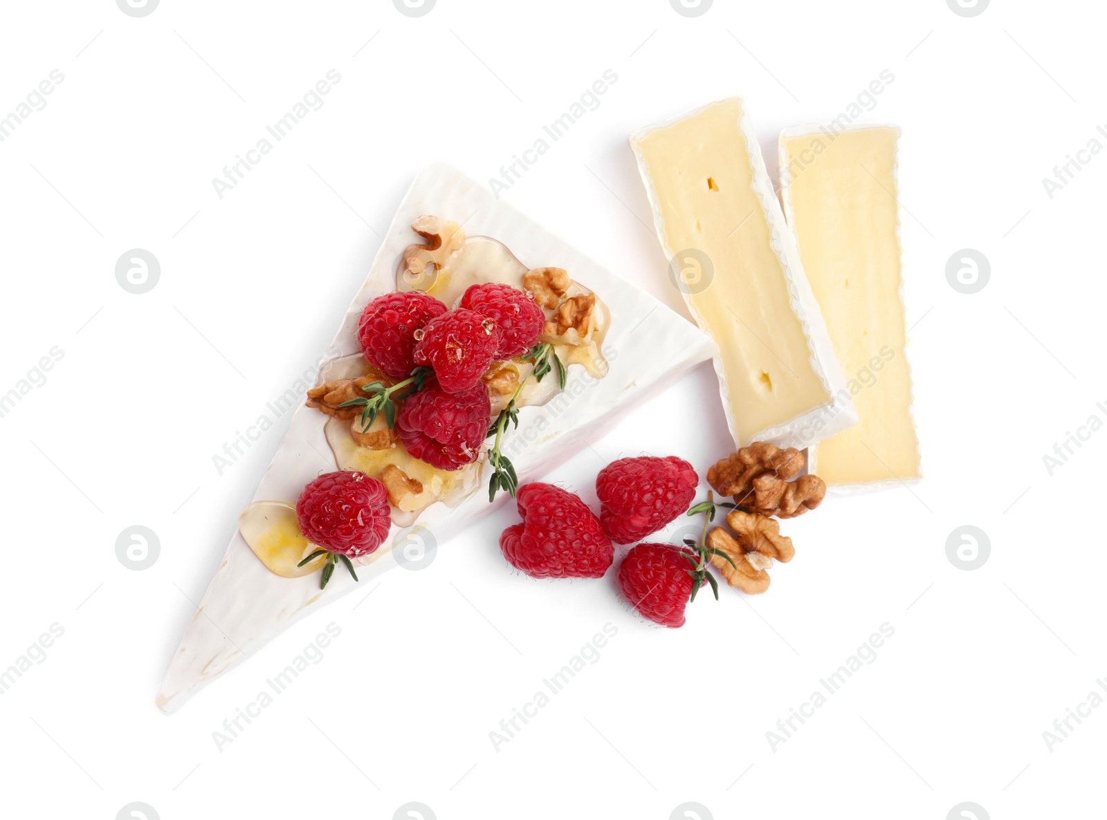 Photo of Brie cheese served with honey, raspberries and walnuts isolated on white, top view