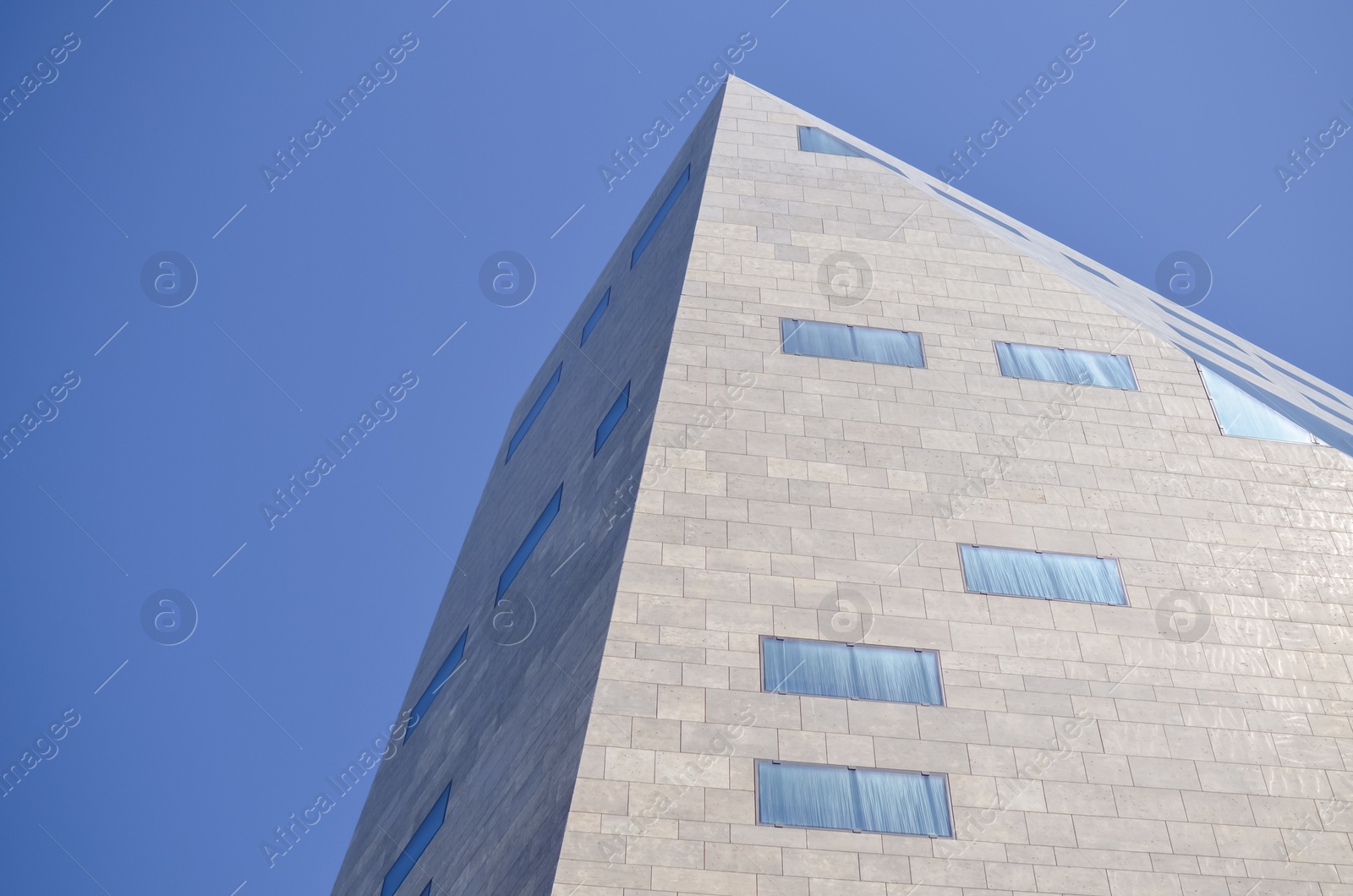 Photo of Beautiful skyscraper against blue sky, low angle view