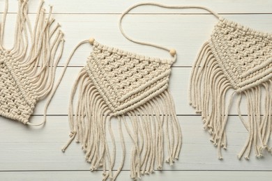Photo of Stylish beige macrame on white wooden table, top view