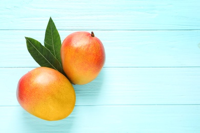 Photo of Flat lay composition with mango on color wooden background. Space for text