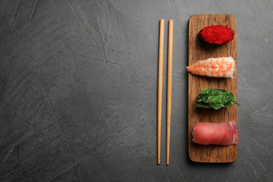 Set of delicious sushi on grey table, flat lay. Space for text