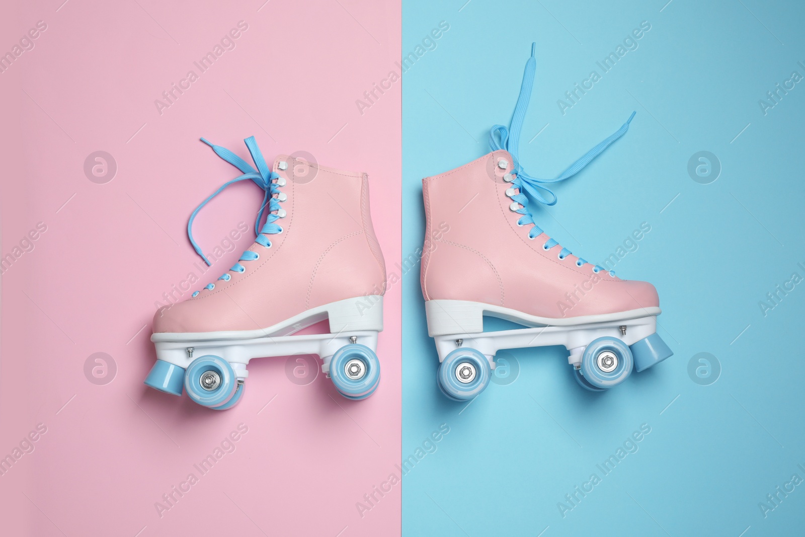 Photo of Pair of stylish quad roller skates on color background, top view