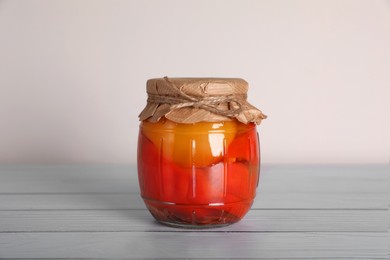 Photo of Jar with pickled bell peppers on white wooden table